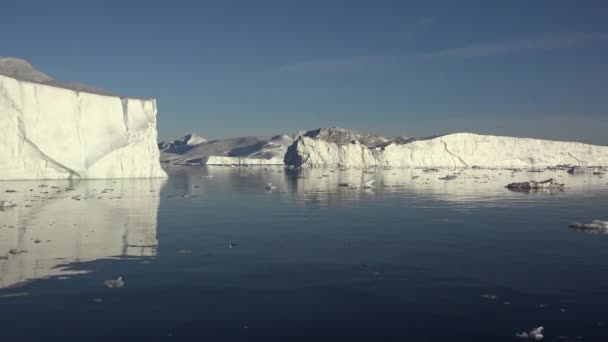 Grönland. Napnyugta-sugarak által megvilágított jéghegyek és gleccserek. — Stock videók