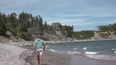 Kanada mı? Okyanus kıyısında yürüyen bir adam