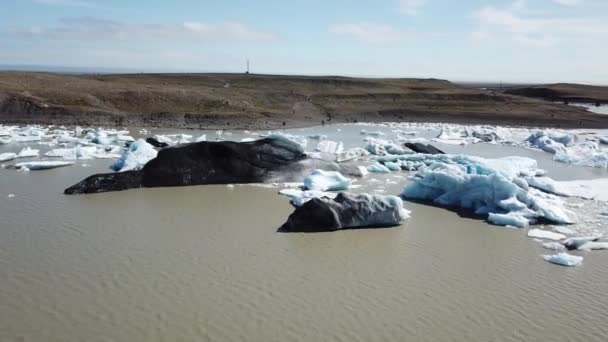 Island, Arktis. Glaciär på stranden. Global uppvärmning. Isberg flyter ut i havet. Flygbilder med drönare Rörelse. — Stockvideo