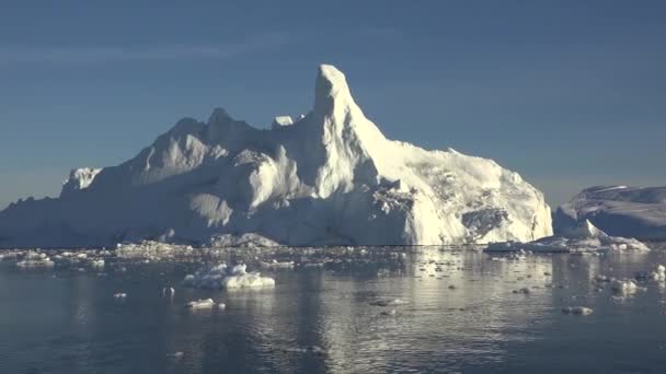 南极洲。美丽的蓝色冰山，镜像反射漂浮在开阔的海洋中。夕阳西下.宏伟的冬季风景。旅行 — 图库视频影像