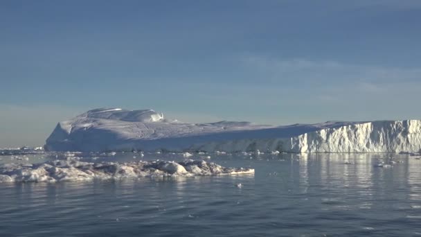 Antarktis. Vackert blått isberg med spegelreflektion svävar i öppet hav. Solnedgång himmel i bakgrunden. Majestätiskt vinterlandskap. Resor — Stockvideo