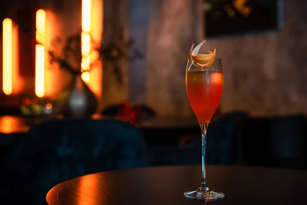 Cocktail met sinaasappelschil decoratie op de tafel — Stockfoto