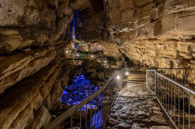Rusya, Soçi, Vorontsovskie mağaraları, 08 Ağustos 2020: RGB ışıklandırmalı turistler için köprüler ve merdivenler
