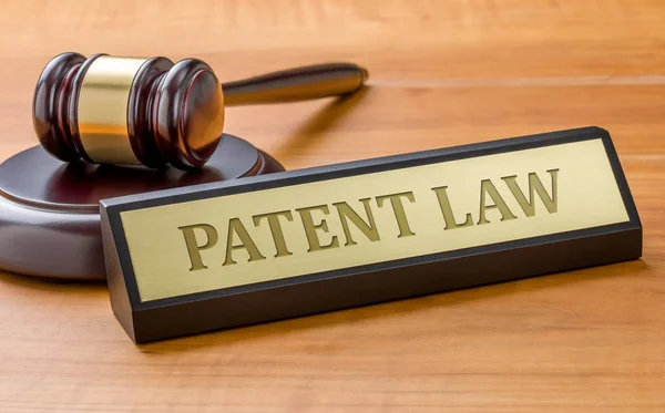 Un mazo y una placa con el grabado Ley de patentes — Foto de Stock