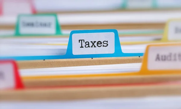 File folders with a tab labeled Taxes — Stock Photo, Image