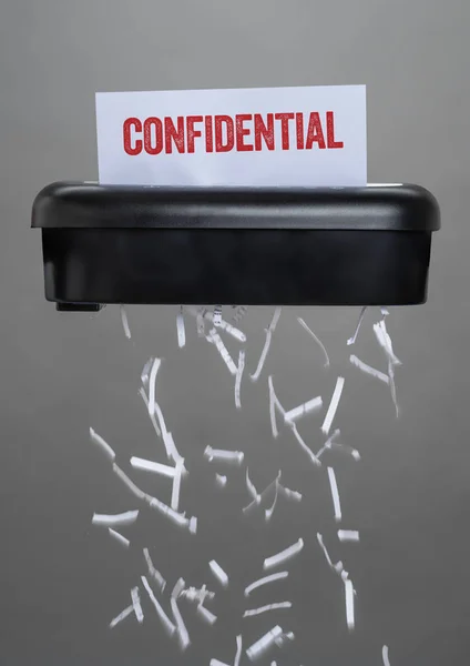 Una trituradora destruyendo un documento - Confidencial — Foto de Stock