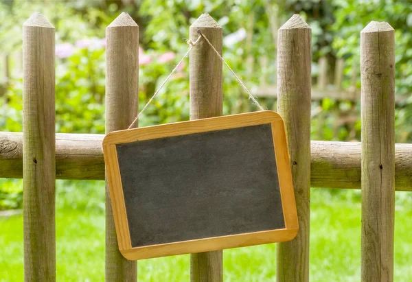An empty blackboard on a wooden fence — Stock Photo, Image