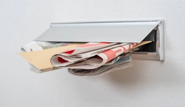 A letter and newspapers in a letterbox — Stock Photo, Image