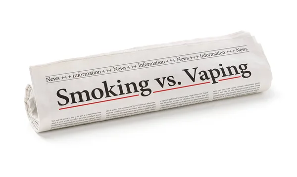 Rolled newspaper with the headline Smoking vs. vaping — Stock Photo, Image
