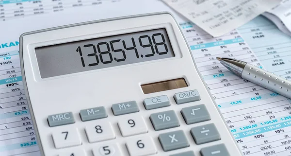 Uma calculadora com uma caneta e alguns documentos — Fotografia de Stock