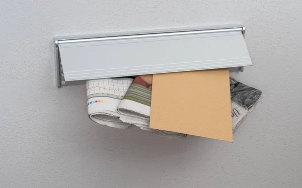 Una carta y periódicos en una ranura de correo — Foto de Stock