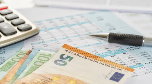 Some euro bills on documents with a calculator — Stock Photo, Image