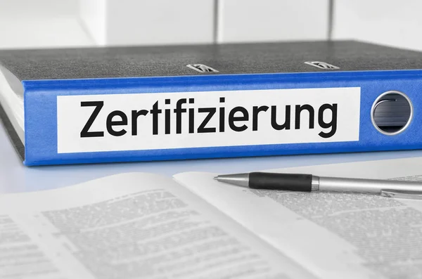 Una carpeta azul con la etiqueta Certificación - Zertifizierung (Ger — Foto de Stock