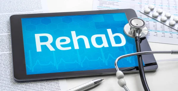 La palabra rehabilitación en la pantalla de una tableta — Foto de Stock