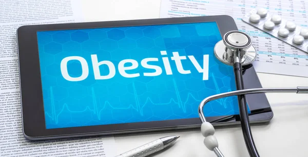 The word Obesity on the display of a tablet — Stock Photo, Image