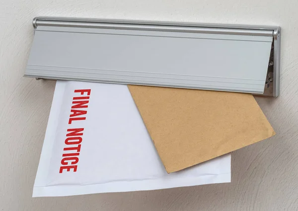 Uma carta rotulada como Aviso Final em uma ranhura de correio — Fotografia de Stock