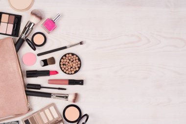 Makyaj kozmetik ve açık bir çanta Beyaz ahşap arka planda, kopya alanı ile üstten görünüm