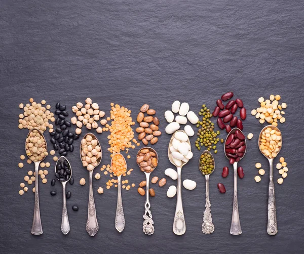 Legumes Lentilhas Chikpea Ervilhas Secas Feijão Colheres Fundo Pedra Vista — Fotografia de Stock