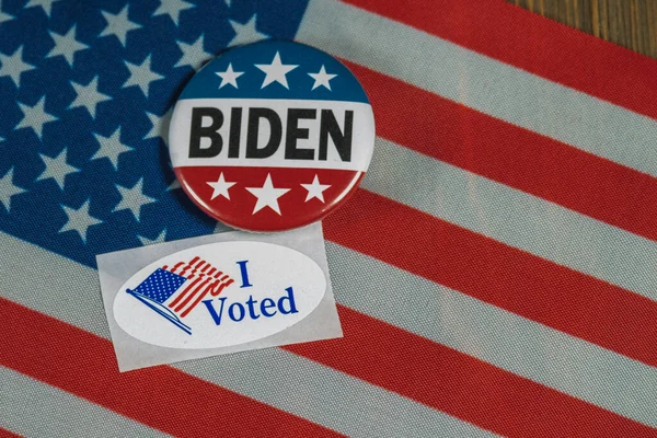 ワシントンDc 2020年7月5日楕円形の横にある丸みを帯びた赤白と青のジョー バイデンのキャンペーンボタン私はアメリカの国旗と木製のテーブルの上に投票ステッカー — ストック写真