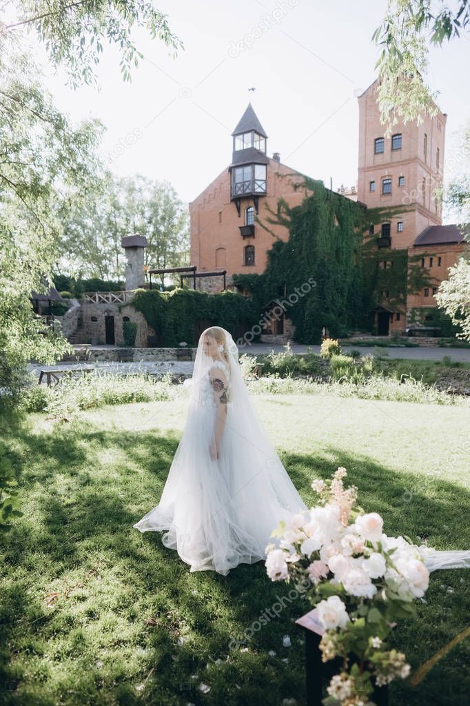 beautiful young bride in garden in front of ancient castle