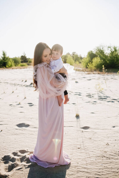 красивая молодая мать с восхитительным малышом на пляже
