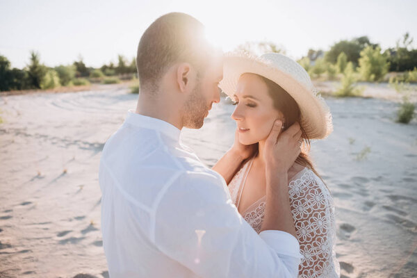 мужчина обнимает красивую молодую женщину на пляже
