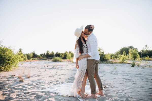 красивая молодая пара целуется и обнимается на песчаном пляже
