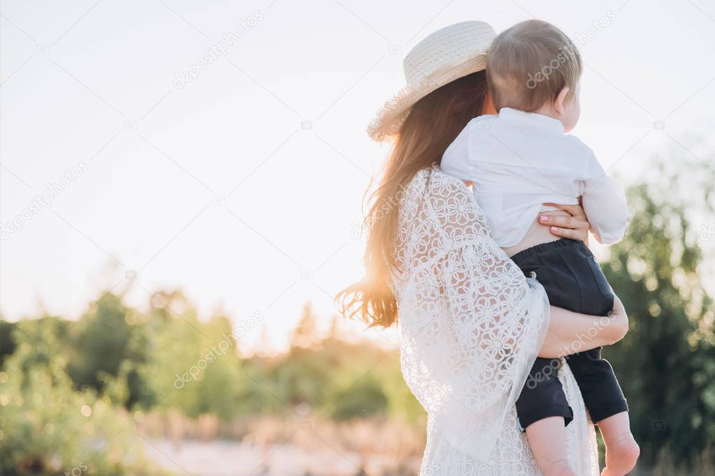 young mother spending time with little son on beach