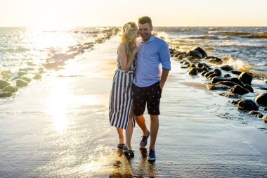 mutlu çift aşık günbatımı sırasında deniz kıyısı Riga, Letonya
