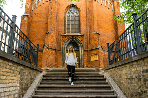 young woman walking down steps on street in Riga, Latvia