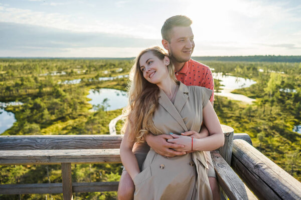portrait of affectionate couple in love hugging on wooden bridge