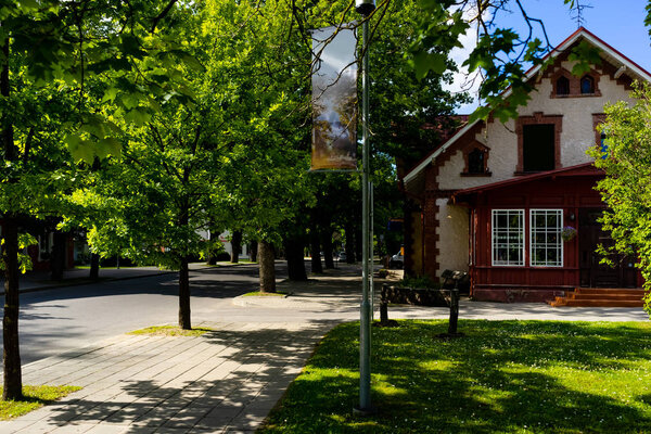 городская сцена с зелеными деревьями на улицах и зданиях в Риге, Латвия
