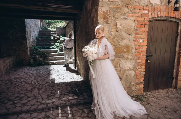 Attractive young bride and groom posing in old town — Stock Photo