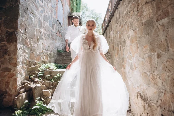 Красивая невеста и жених на лестнице старинного здания в старом городе — стоковое фото