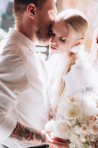 Close-up portrait of beautiful young cuddling bride and groom — Stock Photo