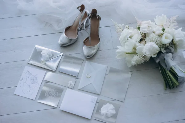 Vista dall'alto di eleganti inviti di nozze con scarpe da sposa e bouquet sul pavimento — Foto stock