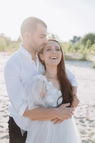 Beautiful happy stylish couple hugging on beach — Stock Photo