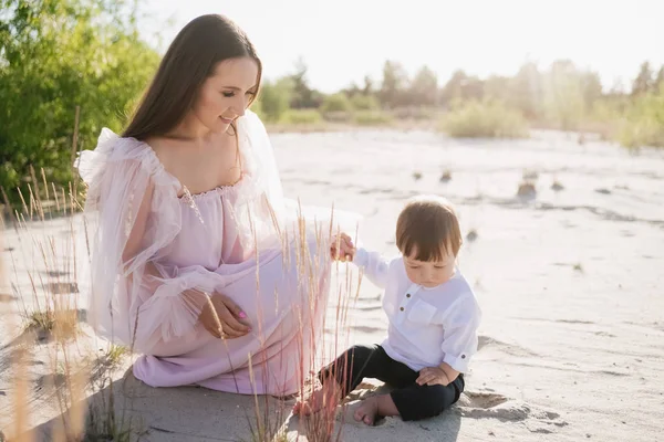 Attractive young mother with little son on beach — Stock Photo