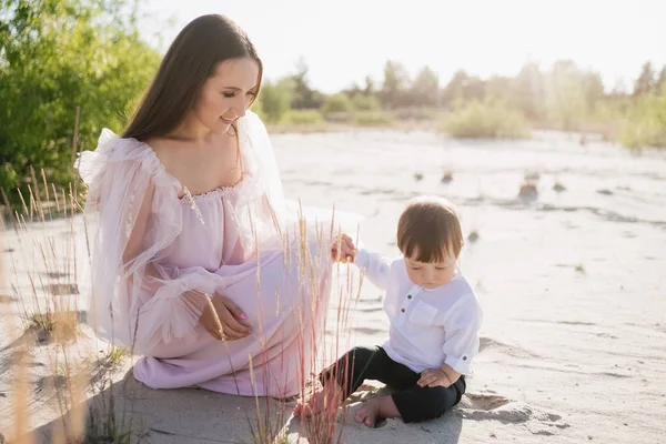 Attraktive junge Mutter mit kleinem Sohn am Strand — Stockfoto