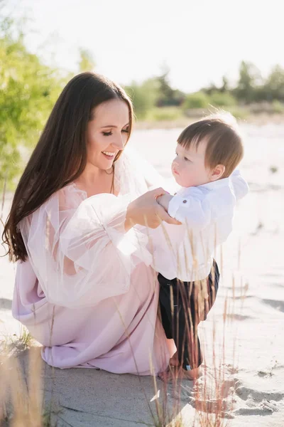 Mère souriante passer du temps avec adorable tout-petit sur la plage — Photo de stock