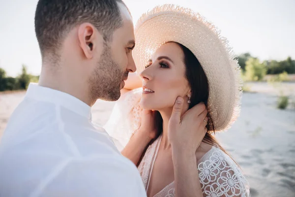 Tenero uomo abbracciare bella giovane donna in cappello — Foto stock