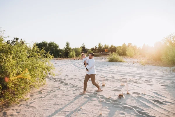 Padre guapo pasar tiempo con su hijo pequeño en la playa de arena - foto de stock