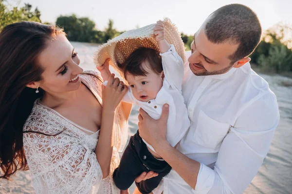 Familia feliz con el niño en la playa - foto de stock