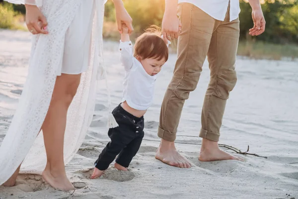 Родители держатся за руки с очаровательным сыном на песчаном пляже — стоковое фото