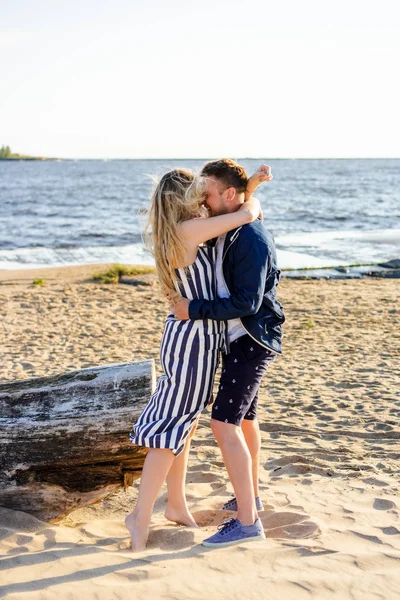 Щаслива романтична пара в любові обіймається на піщаному пляжі з морем на фоні — стокове фото