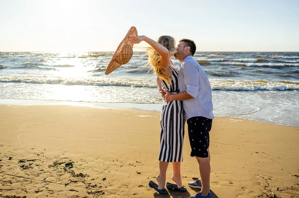 Seitenansicht eines jungen verliebten Paares beim Küssen am Sandstrand in Riga, Lettland — Stockfoto