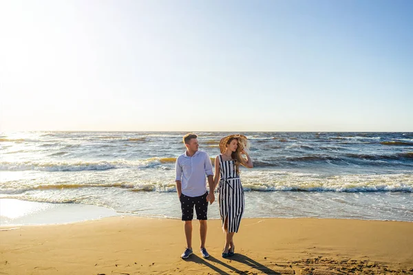 Young couple in love holding hands on sandy beach in Riga, Latvia — Stock Photo