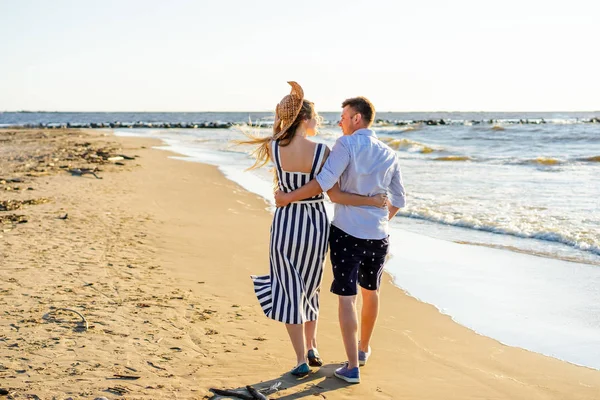 Visão traseira do casal afetuoso andando na praia de areia no dia de verão — Fotografia de Stock