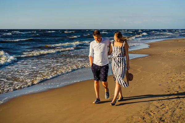 Молодая пара влюбленных обнимается и гуляет по песчаному пляжу в Риге, Латвия — стоковое фото