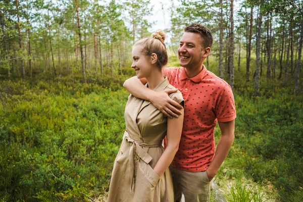 Retrato de hombre feliz abrazando novia con plantas verdes en el fondo - foto de stock